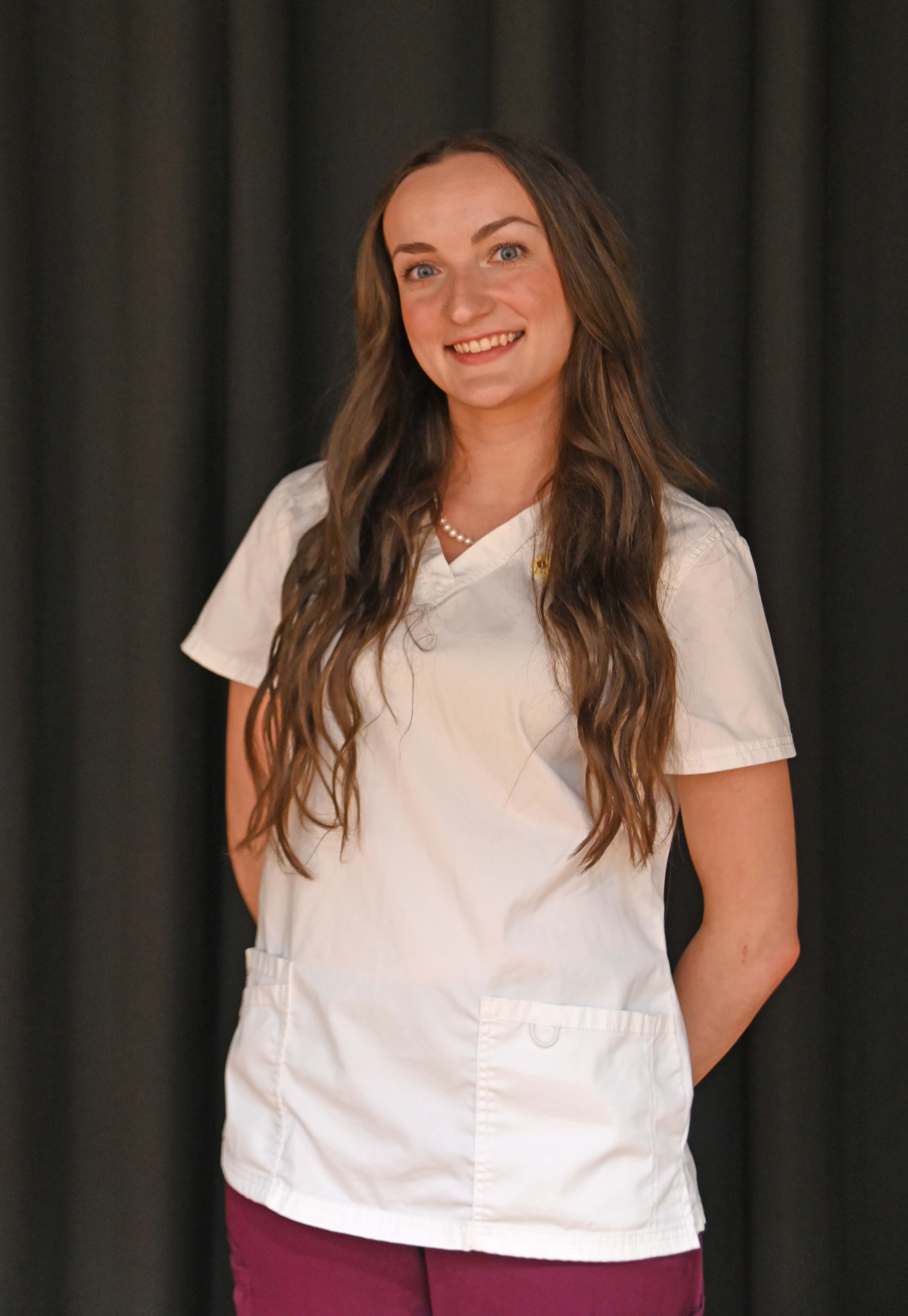 Natalie Johnson posed standing in nursing scrubs
