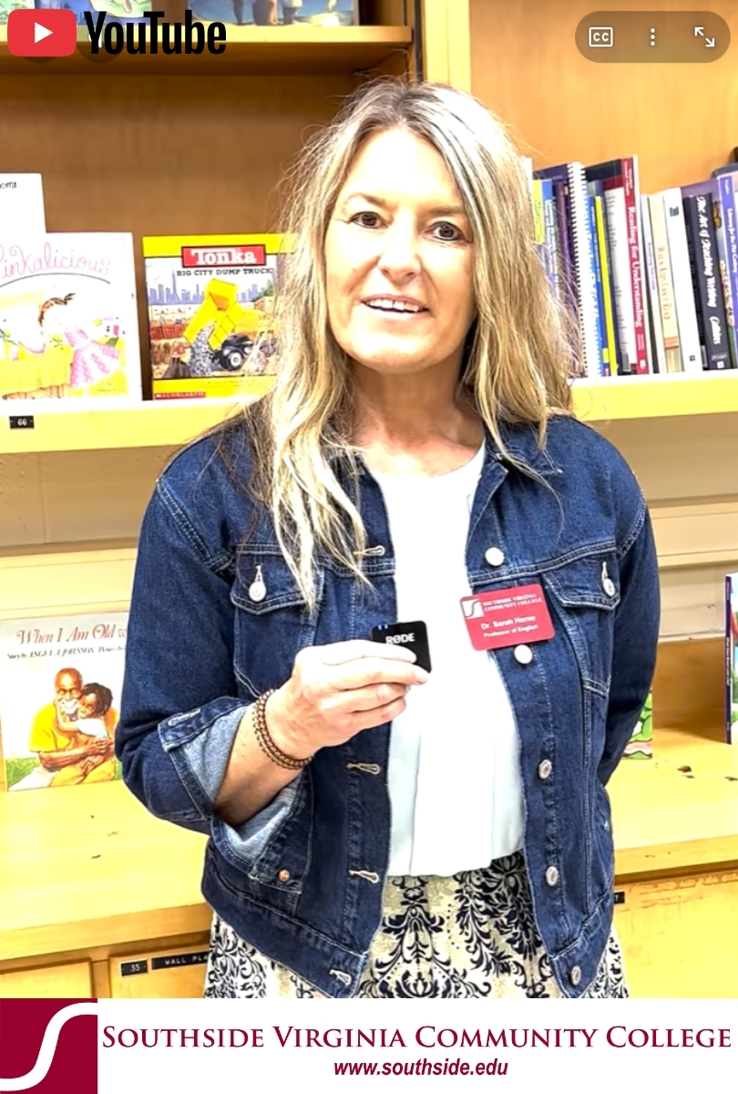 White female teacher in front of bookshelf