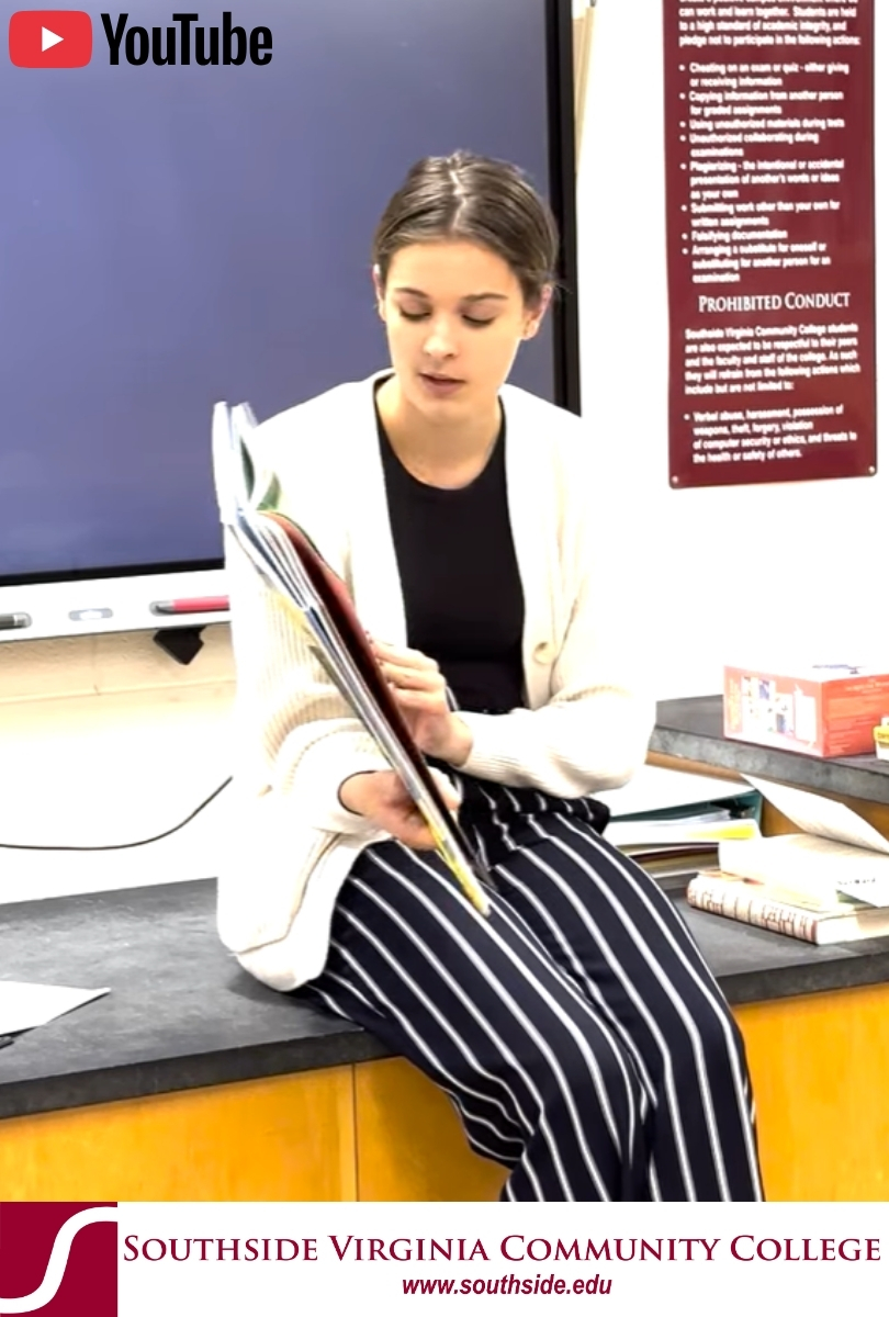 White female student in front of bookshelf