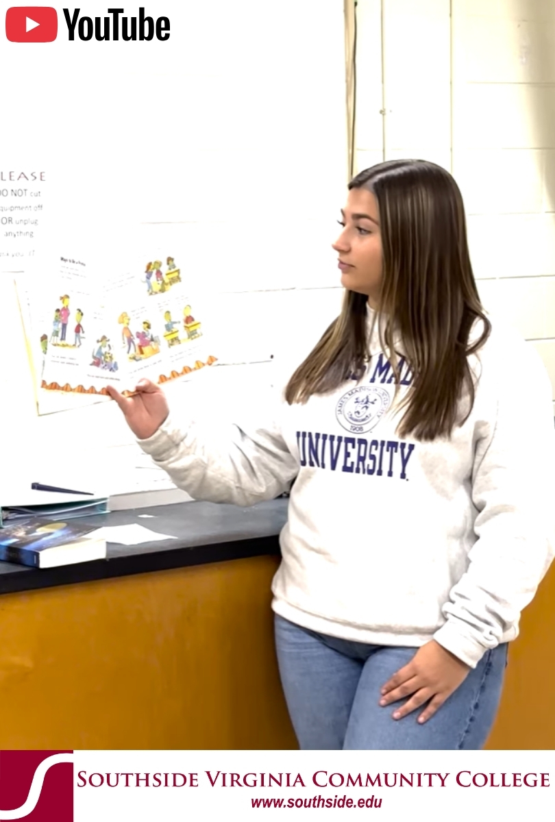 White female student in front of bookshelf
